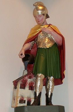 Eine Statue eines Kriegers in kunstvoller Rüstung, mit goldenem Helm und buntem Umhang